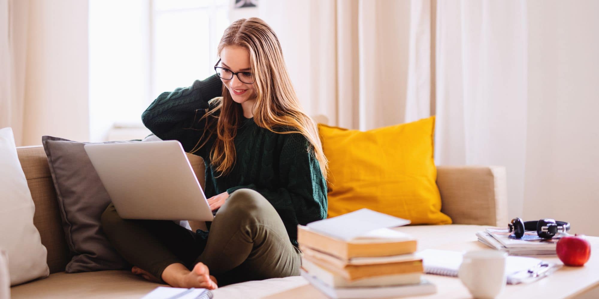 A high school Senior prepares for college at home on her laptop