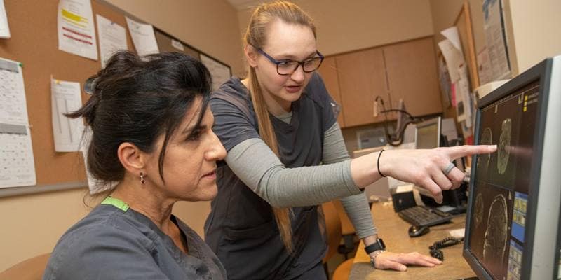 Embry-Riddle Aeronautical University Aerospace Physiology major Morgan Ackermann, right, studies an MRI with Madeline Holleman, MRI Technologist, during an internship at AdventHealth. (Photo: Embry-Riddle / David Massey)